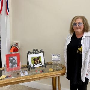 Giselle Armstrong, founder of Action for Animals Maine (AFAM), poses with photos of Butterball, the dog who inspired her to create the organization. ISABELLE CURTIS/Boothbay Register