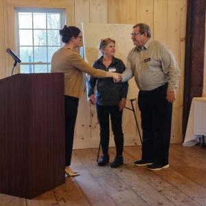 Emily Rabbe, Lincoln County Regional Planning Commission executive director, left, presents a certificate of recognition to Boothbay Harbor for its efforts on the footbridge. Ken Rayle, right, and Lee Corbin, center, accepted the award April 16. Michael Tomko photo