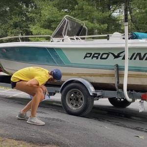 With the permission of its operator, a Courtesy Boat Inspector looks over a boat at the Pemaquid Pond boat landing in Nobleboro. Courtesy of Coastal Rivers