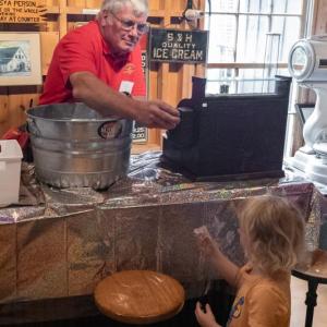 Gerry Gamage hands out a dish of ice cream to a young attendee. Mike Leonard photo