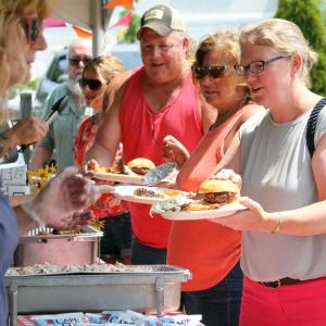 Mike Alley, left, Becky Alley and Maddie Kaler pick up their food at the barbecue. STEVE EDWARDS/Boothbay Register