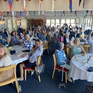 Members of the St. Andrews Auxiliary wave napkins at the volunteer group’s annual summer luncheon. Courtesy photo