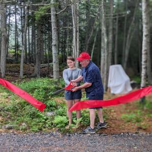 Steve and Madison Gaudette cut the ribbon to open the new Southport Central School woodland playground. CANDI JONETH/Boothbay Register