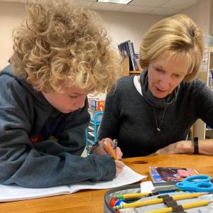 A Midcoast Literacy volunteer tutor helps a student with his reading. Courtesy of Midcoast Literacy