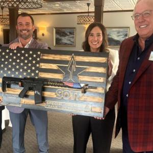 Philanthropist Paul Coulombe, right, receives a unique gift Aug. 15 during a benefit for the Special Operators Transition Foundation. The non-profit group assists miliary special operators transitioning from soldiering into executive business positions. The event was held at Boothbay Harbor Oceanside Golf Resort. Pictured, from left, SOTF CEO Austin Moore, SOTF Director of Development and Corporate Engagement Bobby Payne, and SOTF Operations Coordinator Angie Arias. BILL PEARSON/Boothbay Register