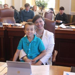 Sen. Cameron Reny with her son, George, at her desk in the Senate Chamber moments before Sen. Reny was sworn in for her second term in the Maine Senate. Courtesy photo