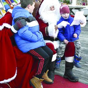 Jonah Curtz, right, shows Santa his drawing of a motorcycle as his brother, Theo, watches. FRITZ FREUDENBERGER/Boothbay Register