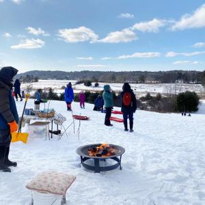 Volunteers tend to the fire and hot cocoa on the big hill at Salt Bay Farm during a Coastal Rivers pop-up sledding party. Courtesy photo 