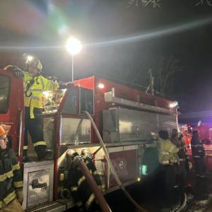 Firefighter Lucian Laurie (Yellow jacket, on Tank 2) running water supply operations and feeding water from Tank 2 to Engine 2. Courtesy of Mark Sullivan