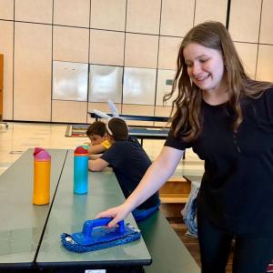 Isabel, daughter of Cashel and Brian Fanslau, makes the most of the opportunity to help clean the EES cafeteria after lunch. Courtesy photo