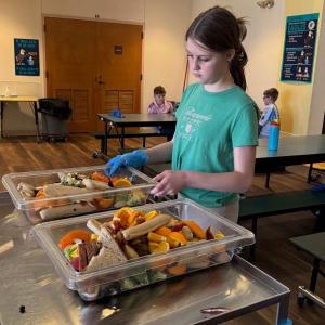 Lilianna, daughter of Trista and Brian Cassidy, collects leftovers to be taken to the compost area next to the EES gardens. Courtesy photo