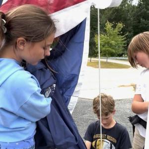 Making sure the flag is handled properly are Maxine, daughter of Pascale and Kirk Zehm;  Sam, son of Daniel and Maureen Cooper;  and Mason, son of Nicole McKay and Patrick Wenners. Students are residents of Alna and Edgecomb. Courtesy photo