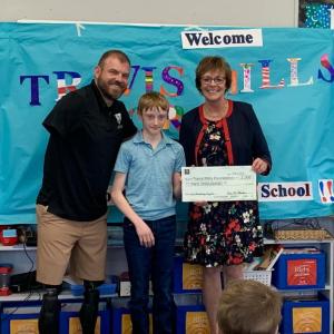 6th grader Duncan Scott helps present the ceremonial check to his chosen charity, the Travis Mills Foundation. Pictured: Travis Mills, Duncan Scott, and principal Lisa Clarke. ISABELLE CURTIS/Boothbay Register 6th grader Duncan Scott helps present the ceremonial check to his chosen charity, the Travis Mills Foundation. Pictured: Travis Mills, Duncan Scott, and principal Lisa Clarke. ISABELLE CURTIS/Boothbay Register