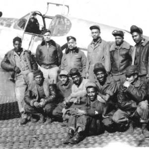 A group of Tuskegee airmen ground crew gather for a photo in front of the Gloria, a P-51 Mustang piloted by Flight Officer Thomas Lawson Hawkins. Courtesy of Bob Sheppard.