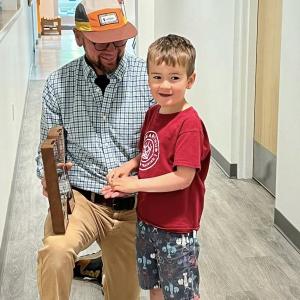 Shawn Gallagher and son Arthur, one of the Y’s Montessori students, donates change to the Camp K Fund donation box. Courtesy of BRYMCA