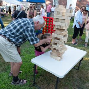 LCHA volunteer Dan Watts assists a youngster with a Jenga tower at last year's Jailhouse Rock event. Courtesy of LCHA