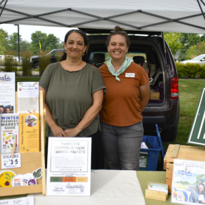 Jaime Berhanu and Kelsey Kobik of the Maine Federation of Farmers' Markets make a local appearance to share information about their organization and celebrate its partnership with the Boothbay market. ISABELLE CURTIS/Boothbay Register