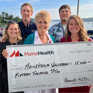 Hilton Family and Cindy Wade, President of LincolnHealth hold a 15,000 check, a donation from the Hilton Family in honor of Brenda Hilton
