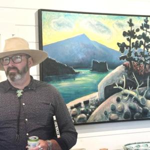 Brunswick-based artist Matt Barter stands in front of his father, Philip Barter's painting, "Spring Evening Grindstone," at the opening reception of their father-son show at Kerr + Jones Fine Art in East Boothbay Sept. 17. LISA KRISTOFF/Boothbay Register