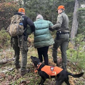 Game Wardens and K9 Storm leave the woods. Courtesy of Maine Inland Fisheries and Wildlife Service Dog
