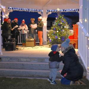 A mother and child share a moment while carolers sing before Santa's arrival Nov. 27 at Boothbay Common. FRITZ FREUDENBERGER/Boothbay Register