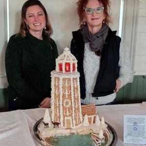 Bethany Trussell and Mary Jo Marquis with their gingerbread Burnt Island Light...and visitors. Courtesy of KBIL