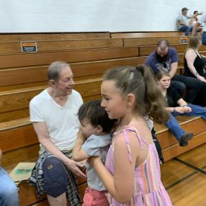 Kinsley Waite, 8, carries cousin Levi Daly, 2, in Wiscasset Middle High School’s Stover Auditorium June 5, before Waite’s brother Dominic Waite graduated. SUSAN JOHNS/Wiscasset Newspaper