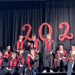 Some of their seated classmates look on as three graduating Wiscasset Middle High School seniors share a moment June 5. SUSAN JOHNS/Wiscasset Newspaper