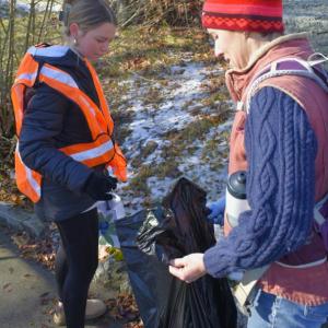 Maddie Andreasen, left, disposes of trash with the help of teacher Emily Higgins. FRITZ FREUDENBERGER/Boothbay Register 