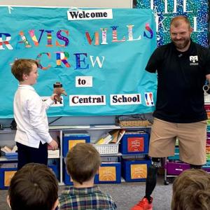 Travis Mills shows off his prosthetic's detachable hand function with the help of a Southport student. ISABELLE CURTIS/Boothbay Register