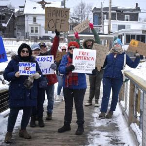 Locals walk down the footbridge in Boothbay Harbor as part of the national "Free America" protest. ISABELLE CURTIS/Boothbay Register