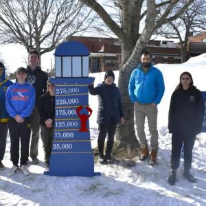After much shoveling, nailing and adjusting, the Boothbay Region Student Aid Fund's new sign is installed on the high school lawn Feb. 4. Pictured:  Sarah Baldwin, Chip Schwehm, Zander Blake, Nathan Percival, Harry Hinkley, Abby Orchard, Hildy Johnson, Chris Liberti and Preston Giles. Not pictured: Brandon Seigars, Mathew Jackson, Spencer Wood and Cameron Lewis. 