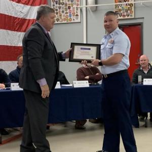 Mike Tomko presents a representative of U.S Coast Guard Boothbay Harbor with the Spirit of America Tribute. ISABELLE CURTIS/Boothbay Register