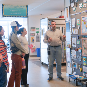 Senior Research Scientist Mike Lomas shows WWF colleagues a display that spotlights the history, reach, and impact of the NCMA (Credit: Alex Seise)