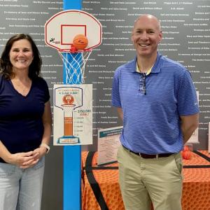 Lesley and Brian Blethen stand next to the fundraising thermometer. They are helping to raise money for new bleachers in the Boothbay Region YMCA gym. Courtesy photo