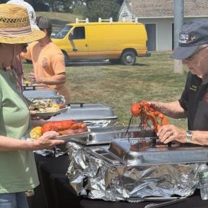 Boothbay Harbor fireman Arthur Richardson serves up a lobster during the Aug. 1 Lobster Bake. BILL PEARSON/Boothbay Register