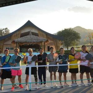 Wide-shot pickleball players at the net in front of Sala. Courtesy of FTD