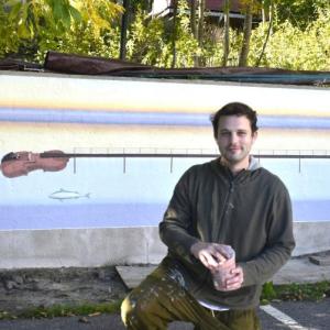 Artist Dan Nielsen set against his mural design in progress on the back wall of the Opera House parking lot. LISA KRISTOFF/Boothbay Register