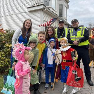 A group stops for a photo with Boothbay Harbor police officers near Grover's Hardware during the 2025 parade. Bethany Schmidt photo