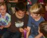 Elementary school students hold and study Ellie Logan's Olympic gold medal. KEVIN BURNHAM/Boothbay Register