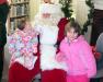 Sisters Kayla, left, and Ella Watts of Southport share a moment with Santa at the Memorial Library. GARY DOW/Boothbay Register
