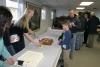 Sarah Sample cuts one of the cakes for the children and adults. KEVIN BURNHAM/Boothbay Register