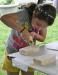 A young girl crafts a wooden boat under the Kids' Tent. KEVIN BURNHAM/Boothbay Register