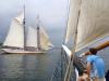 Ron Adolf, a passenger on the Lewis R. French, hangs his feet over the bow as we watches the Heritage sail into Boothbay Harbor. RYAN LEIGHTON/Boothbay Register 