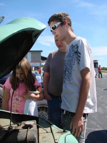 Alannah Bryer, left, age 9, father Darrell Bryer and Alannah's brother Ian Bryer, 15, all of Wiscasset, look over a 1948 Crosley at an antique auto display during the Wings event. SUSAN JOHNS/Wiscasset Newspaper